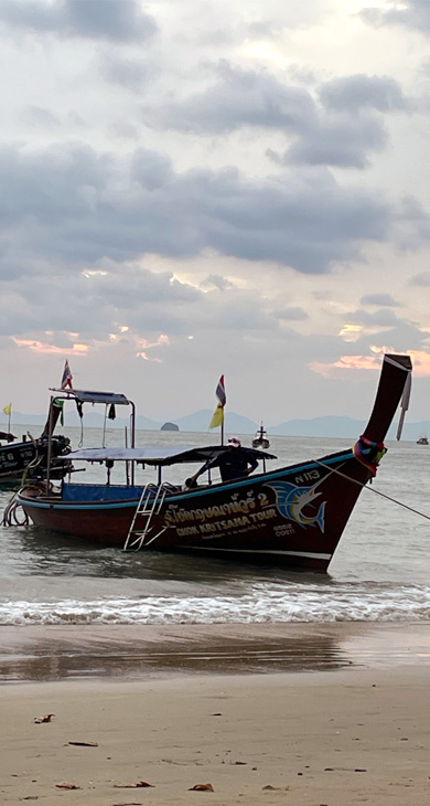 A longboat at the beach during sunset