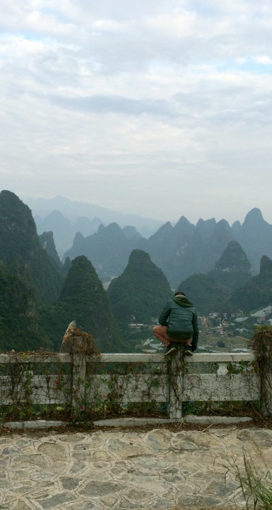 Man on a fence with view of lime stone cliffs